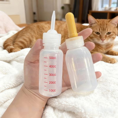biberon pour chaton tenu en main sur canapé blanc