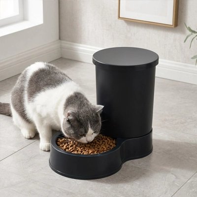 Distributeur de croquettes pour Chat noir et blanc mangeant son repas