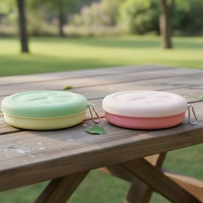 Gamelle pour chat rose et vert sur table de picnic